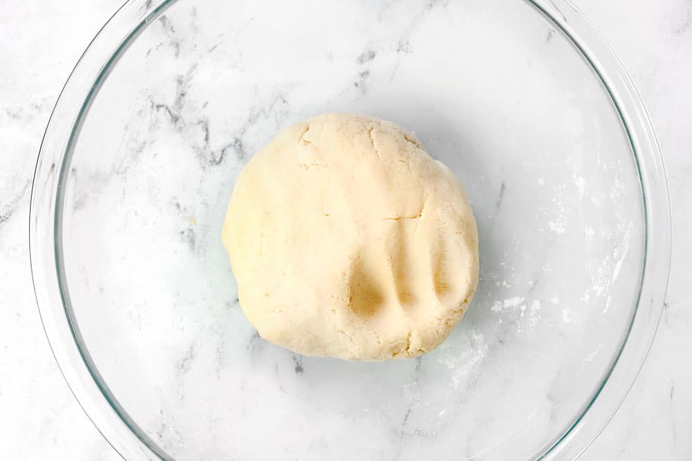 showing how to make homemade corn tortillas by kneading the dough into a smooth ball