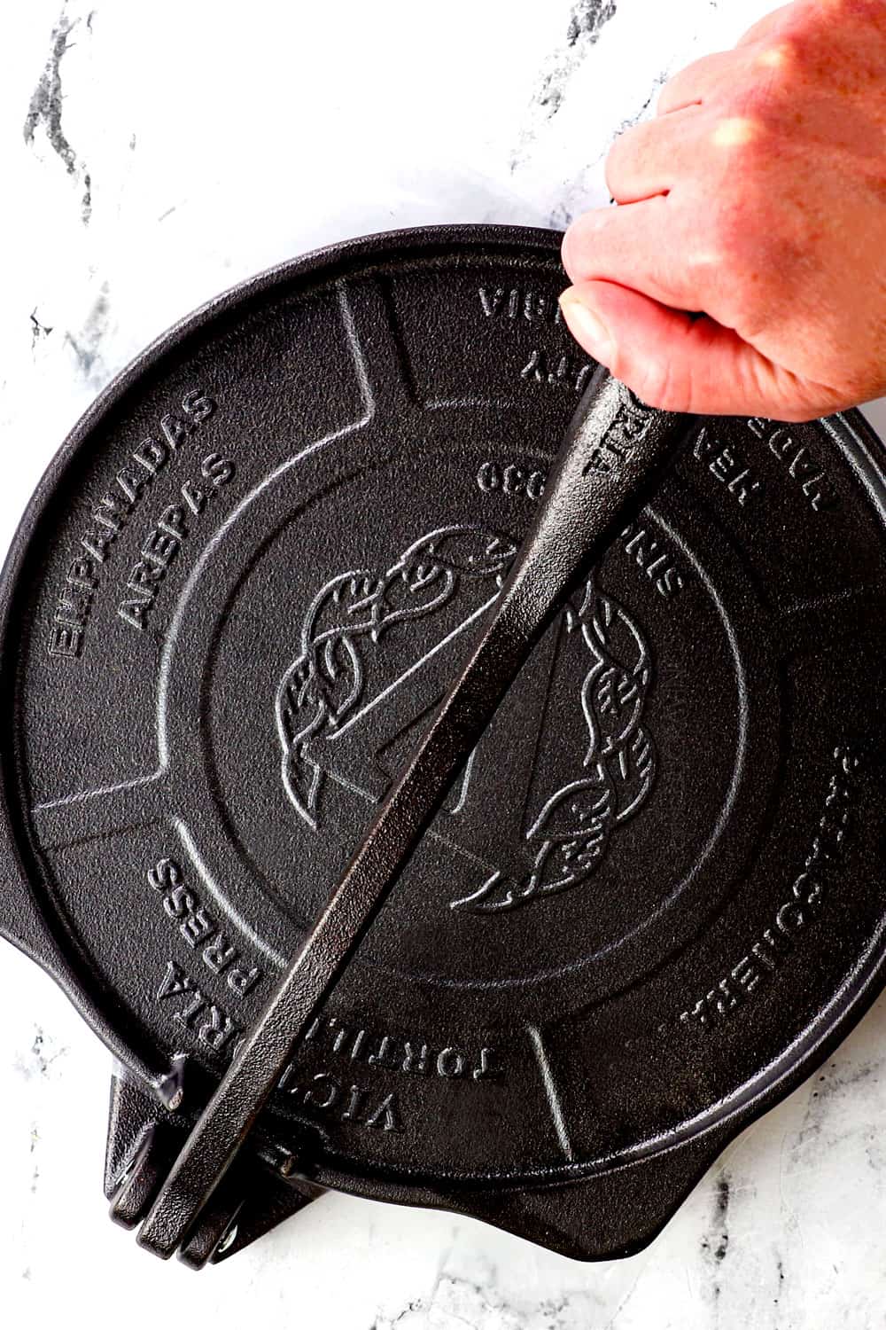 showing how to use a tortilla press to make tortillas by pressing firmly down with the handle