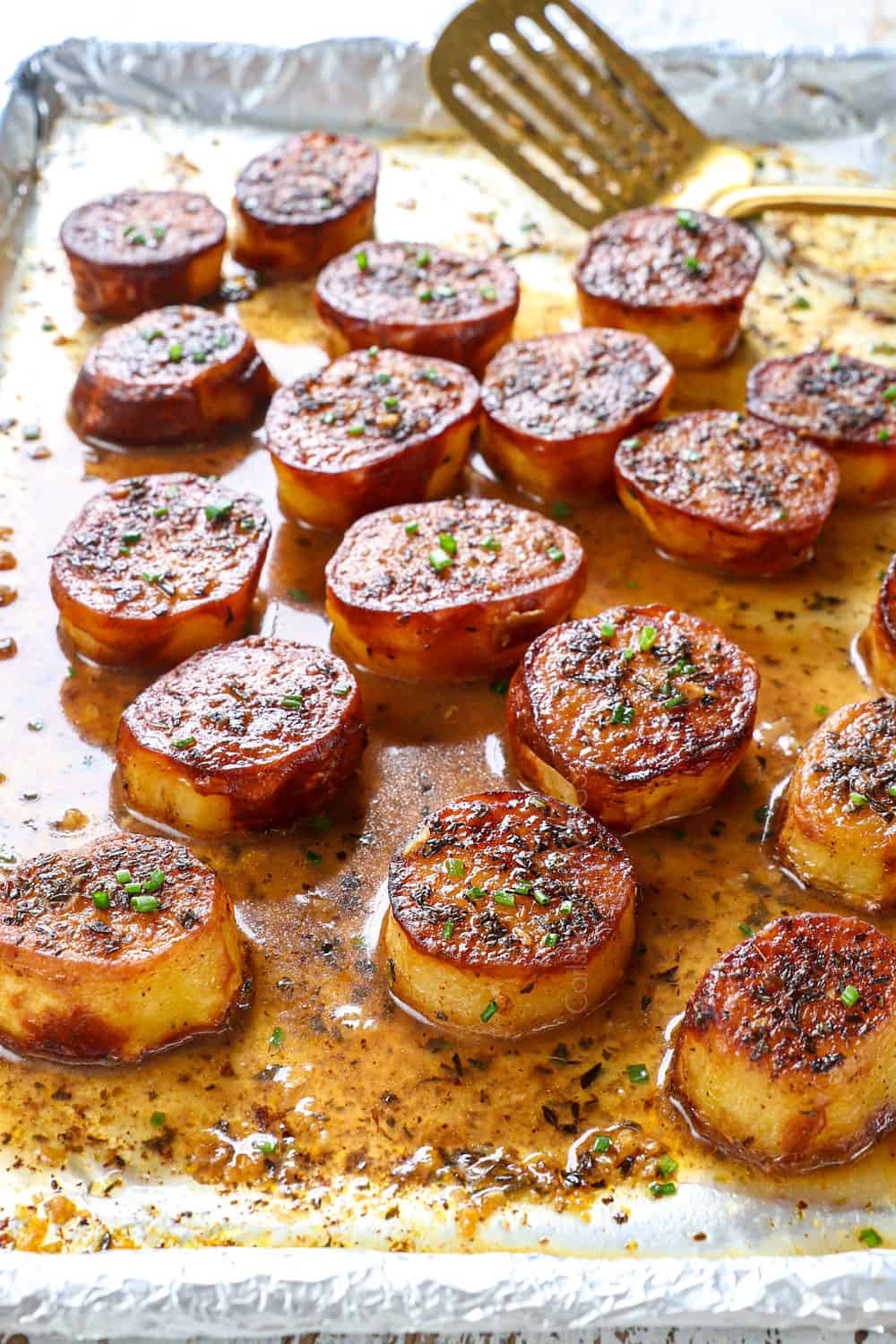 a baking sheet full of melting butter potatoes with chicken broth