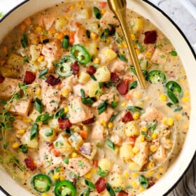 top view of salmon chowder in a Dutch oven with potatoes, corn and bacon