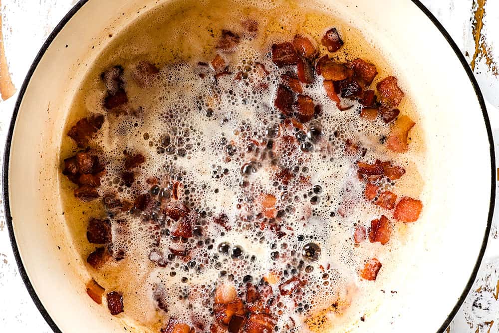 showing how to make fish chowder recipe with salmon by cooking bacon in a Dutch oven until browned and crispy