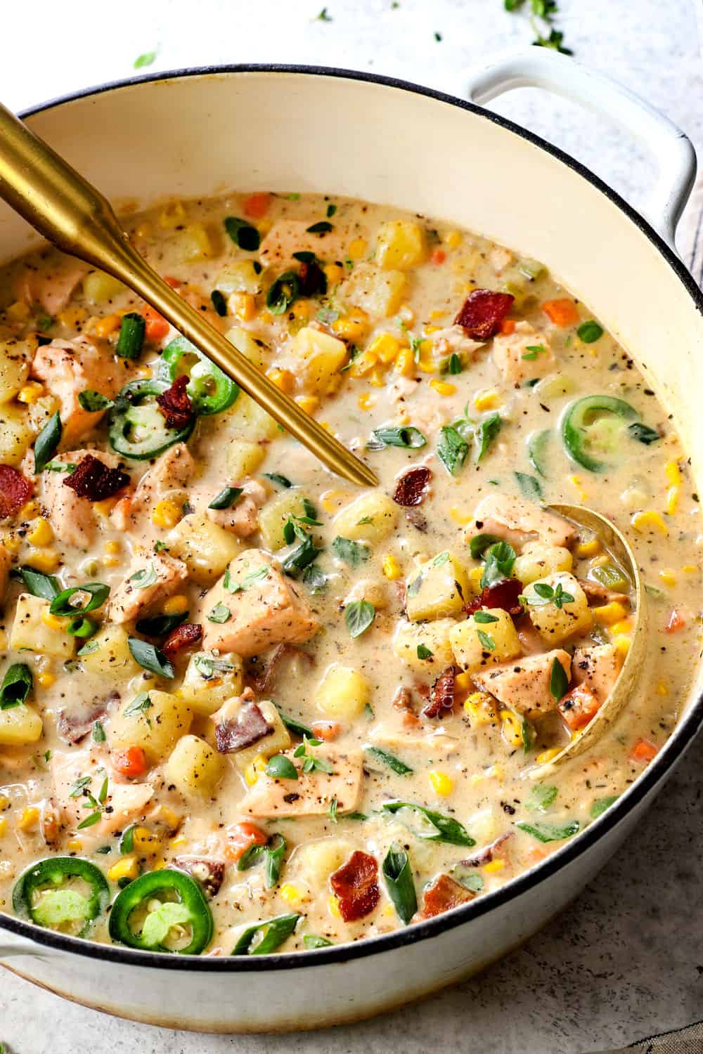 fish chowder with salmon in a Dutch oven with a ladle showing how creamy it is