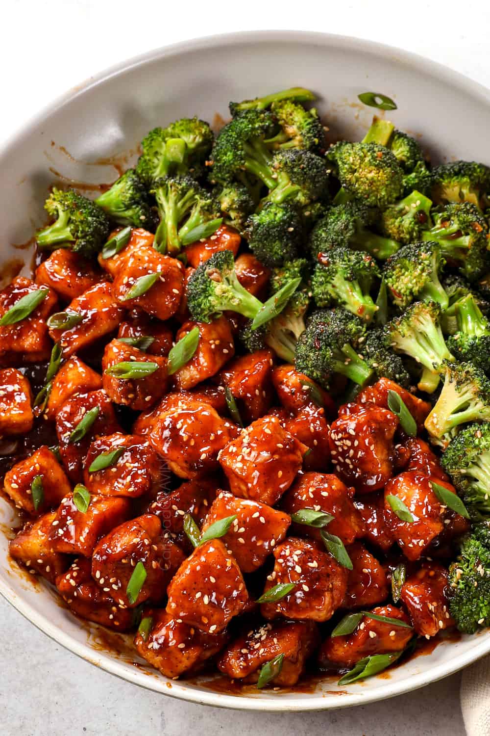 honey sesame chicken in a skillet with sesame sauce