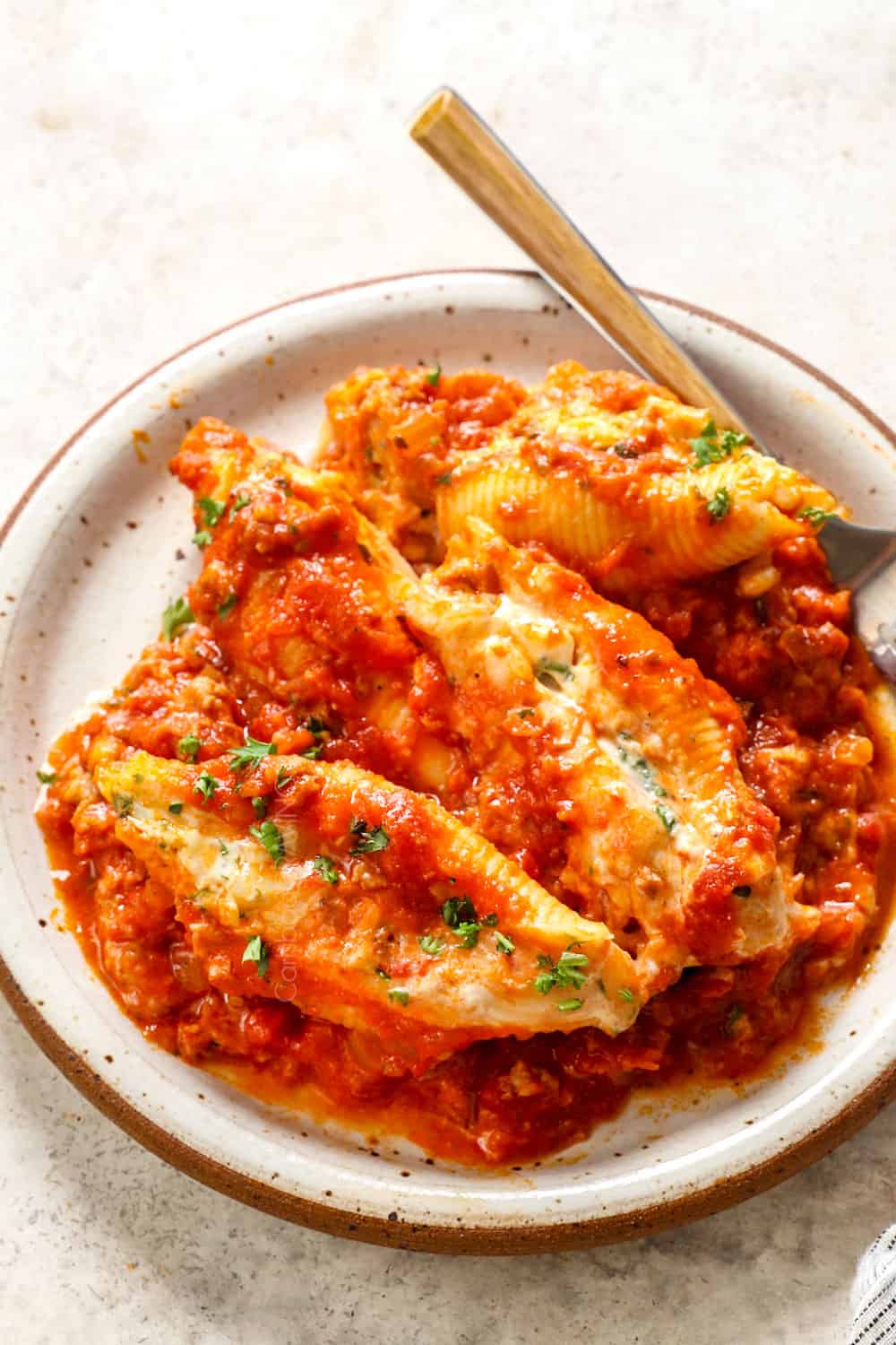 up close of stuffed pasta shells with sausage, ricotta and herbs in marinara sauce