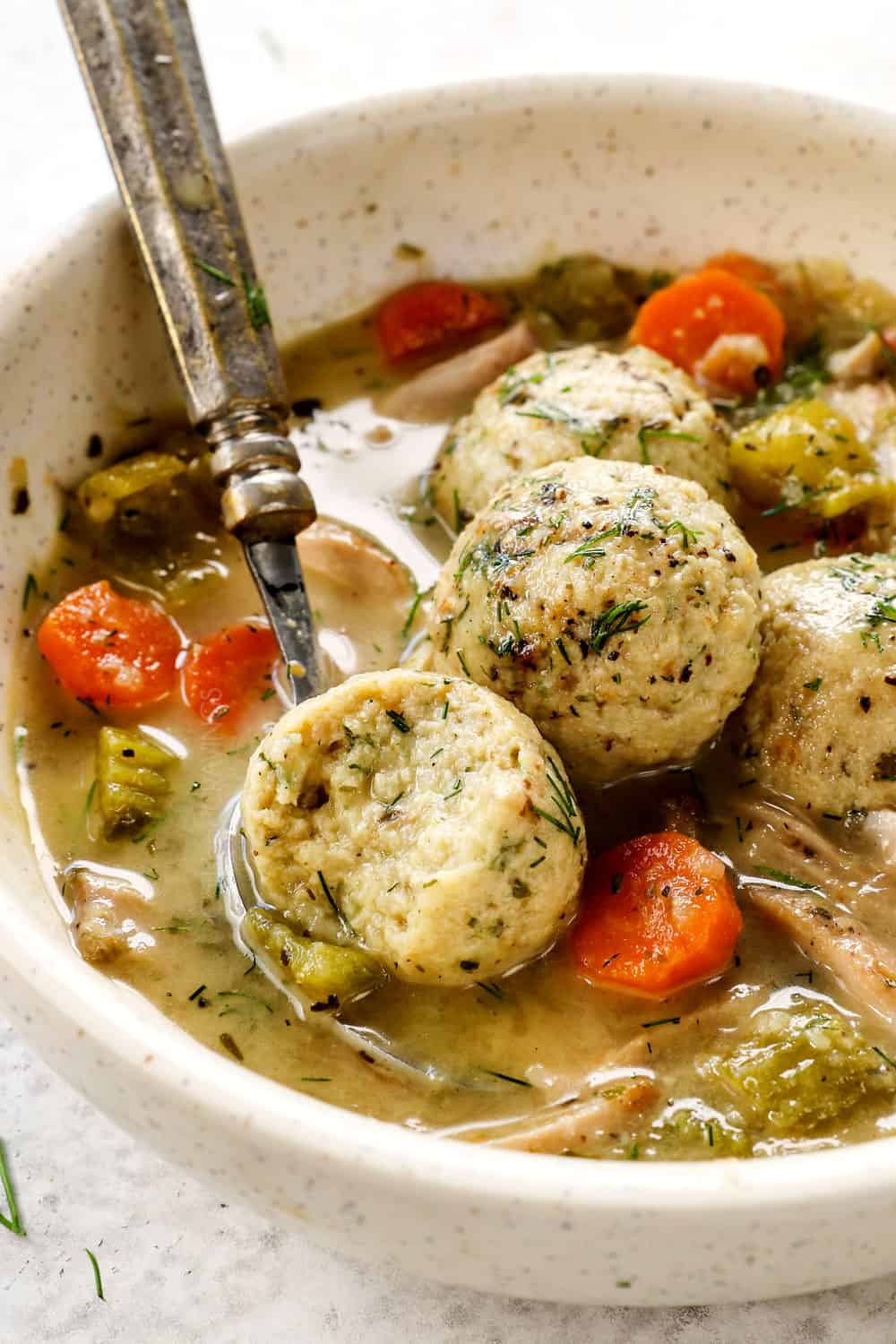 up close of a floater, fluffy matzo ball in the soup