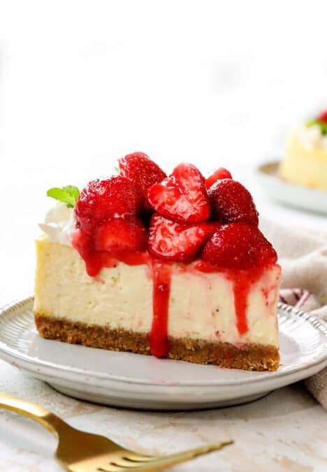 front view of a slice of strawberry cheesecake showing the glazed strawberry topping