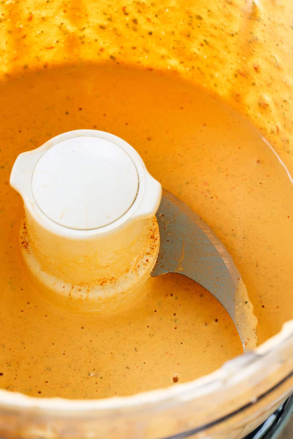 showing how to make chipotle sauce recipe by blending chipotle peppers in adobo, adobo sauce, sour cream, mayonnaise, garlic, lime juice and cilantro in a food processor until creamy