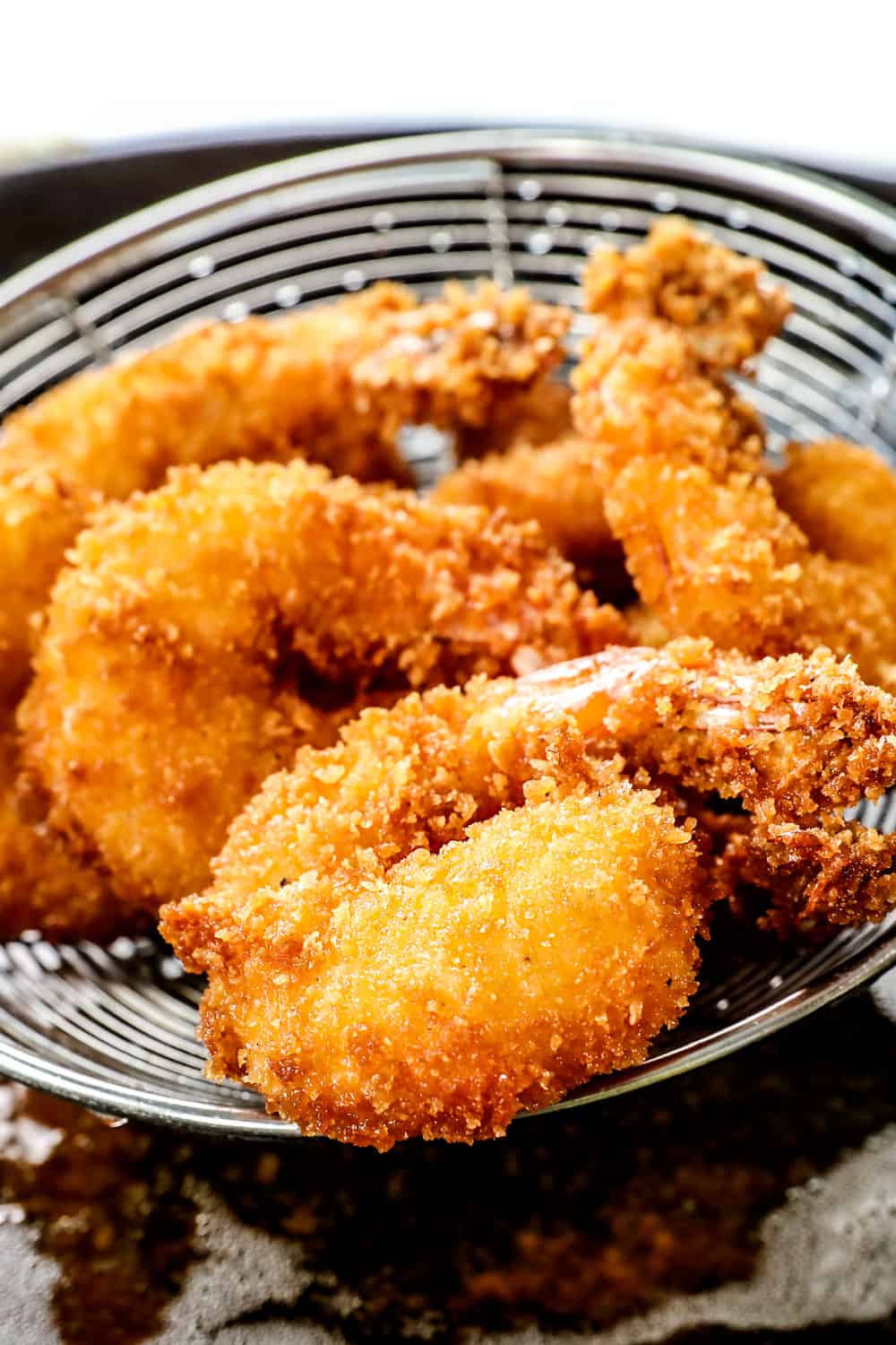 showing how to make crispy panko fried firecracker shrimp by deep frying until golden