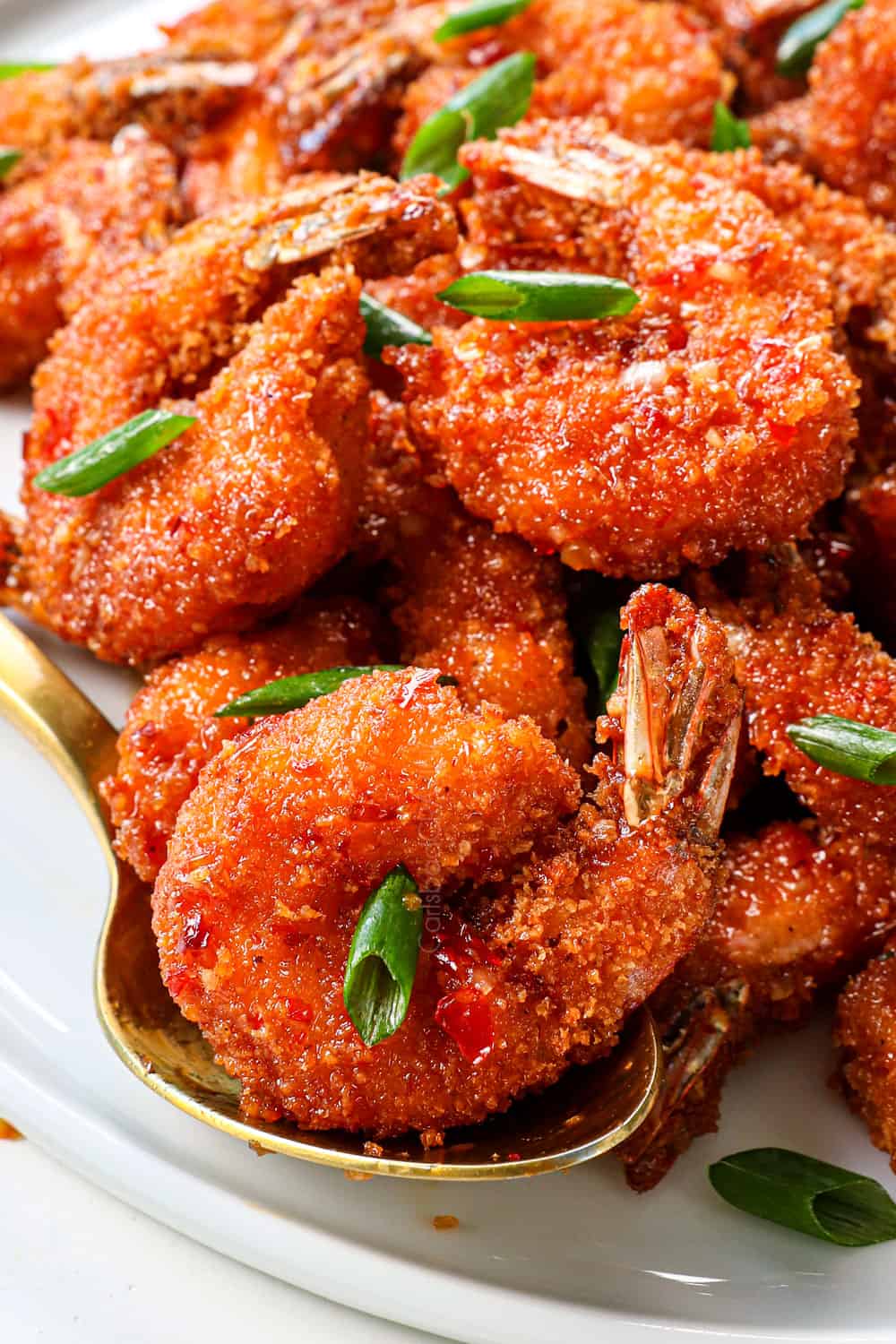 serving firecracker shrimp recipe on a platter garnished by green onions