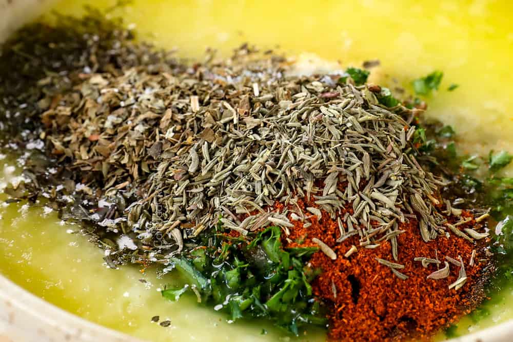 showing how to make lemon pepper salmon recipe by whisking together lemon pepper, butter, garlic, lemon juice, paprika, dill and parsley in a bowl