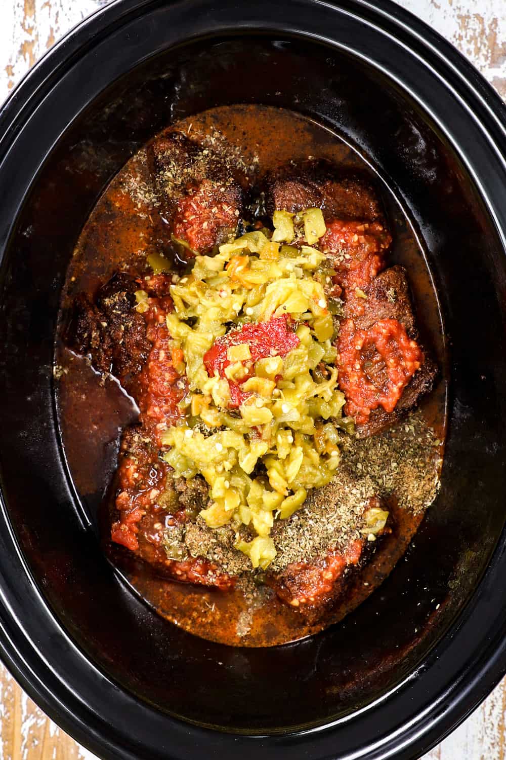 showing how to make taquitos recipe by adding beef, beef broth, salsa and seasonings to a slow cooker