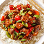 top view showing how to serve black pepper chicken by adding to a bowl of rice and topping with green onions