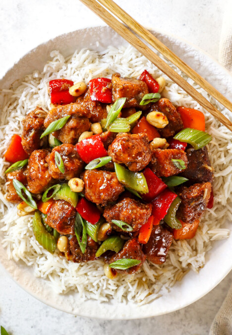 top view showing how to serve black pepper chicken by adding to a bowl of rice and topping with green onions