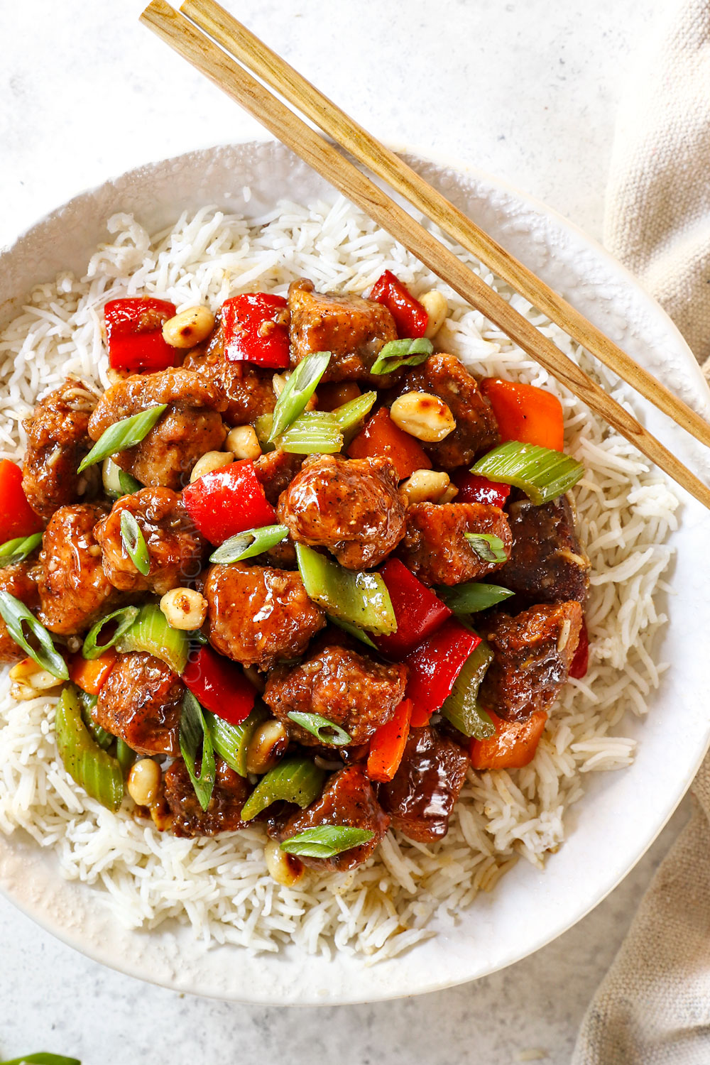 top view showing how to serve black pepper chicken by adding to a bowl of rice and topping with green onions
