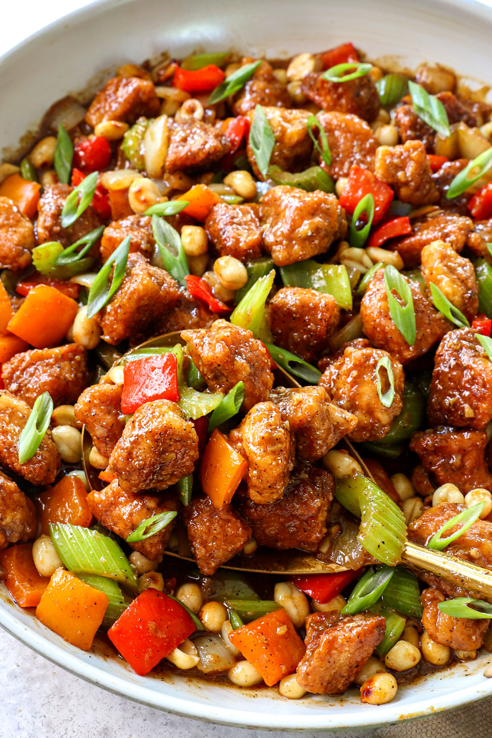 scooping up Panda Express black pepper chicken by scooping up with a serving spoon