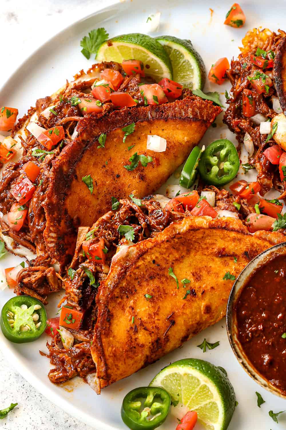 serving chicken birria tacos on a platter showing how crispy they are