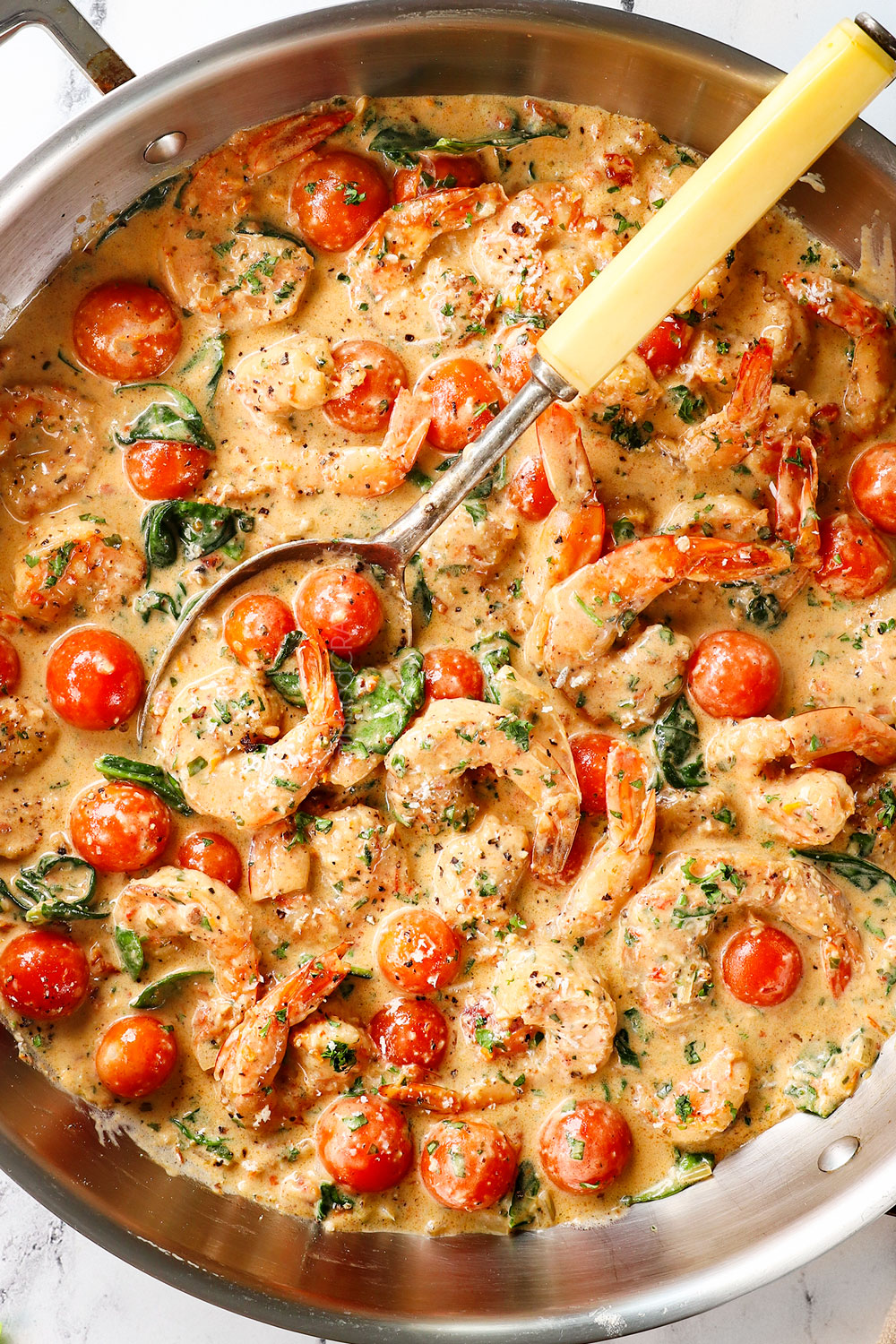 top view of Tuscan shrimp in a skillet with garlic and sun-dried tomatoes