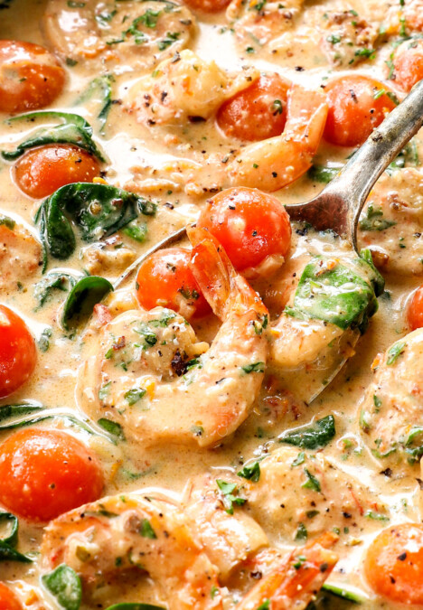 up close of scooping up creamy Tuscan shrimp with garlic