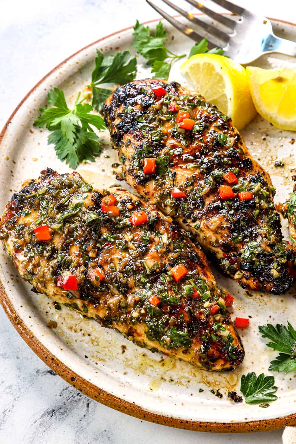 chimichurri chicken on a plate topped with chimichurri sauce