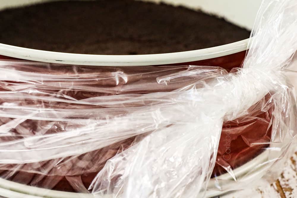 showing how to make Oreo cheesecake recipe by waterproofing the springform pan with a slow cooker liner