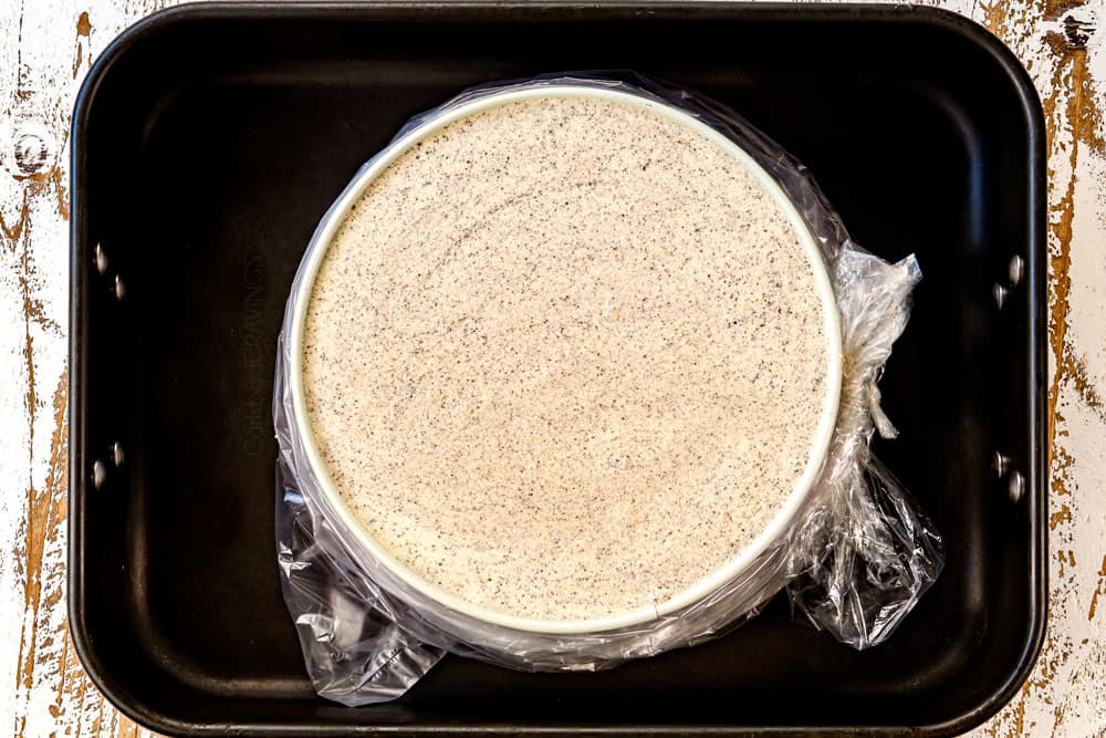 showing how to make Oreo cheesecake recipe by adding cheesecake to a water bath in a roasting pan