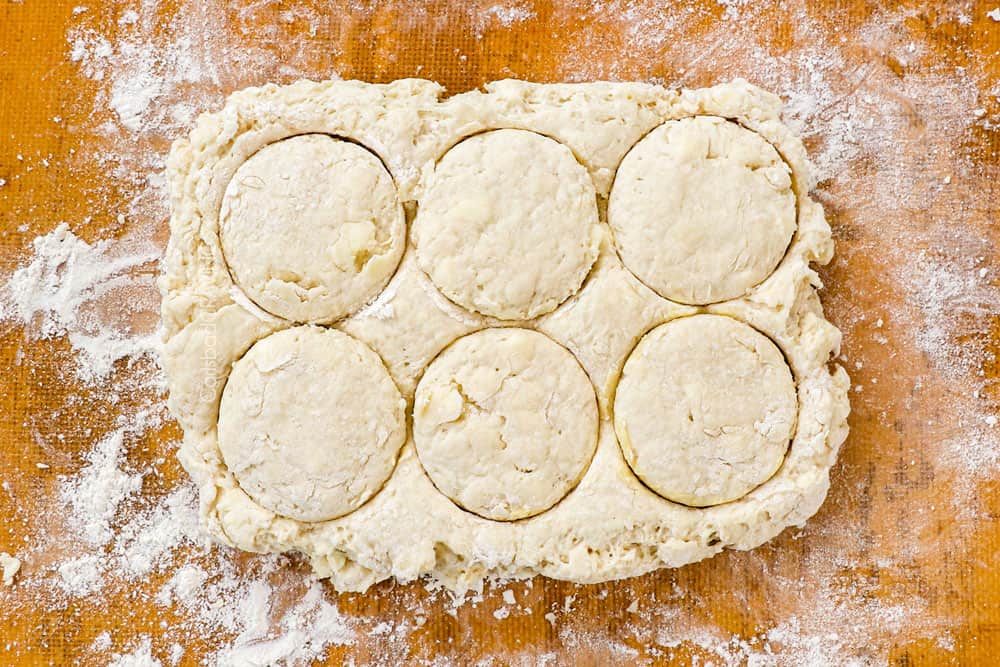 showing how to make homemade biscuits and gravy recipe by cutting biscuits into dough