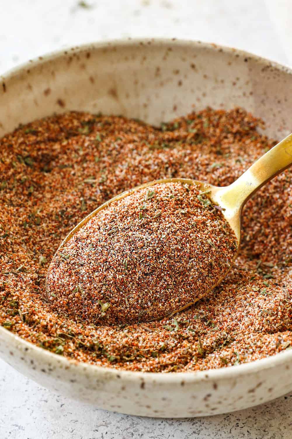showing how to make jerk chicken tacos by whisking together jerk seasonings in a bowl