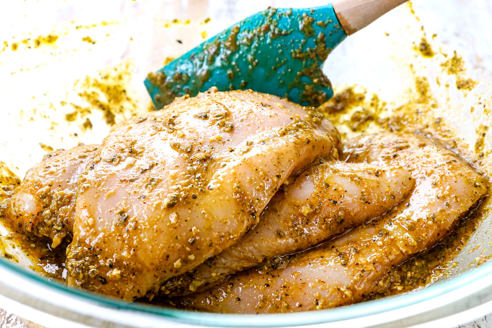 showing how to make Mediterranean Chicken Salad by marinating the chicken in a pesto marinade