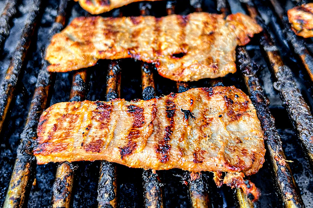 showing how to make banh mi sandwich recipe by grilling pork until deeply seared