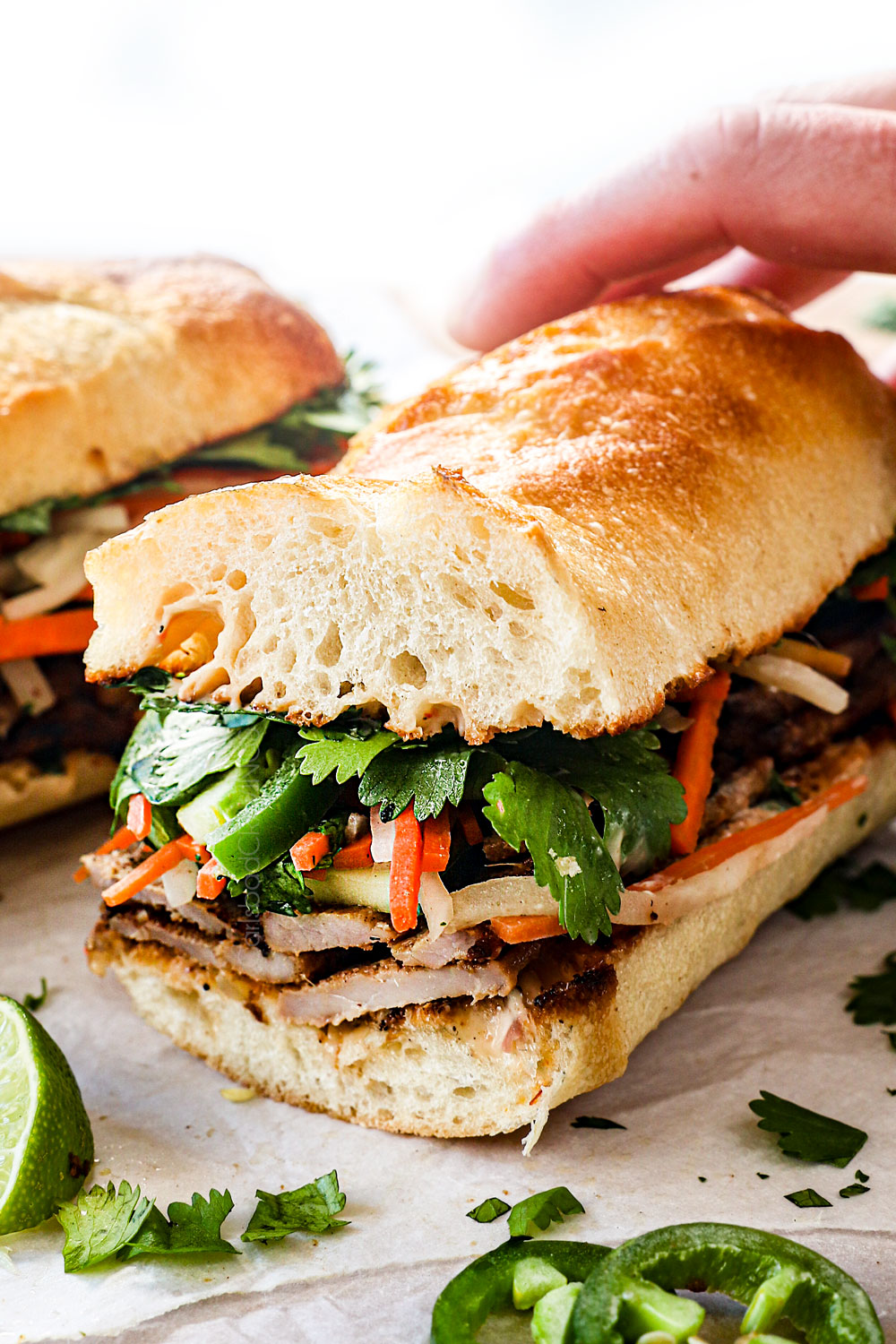 showing how to serve Banh Mi Vietnamese Sandwich by slicing the sandwich in half