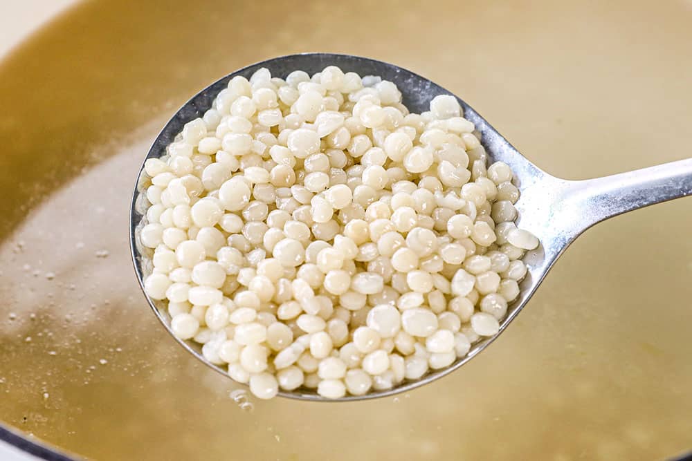 showing how to make couscous salad recipe by simmering couscous until al dente in chicken broth