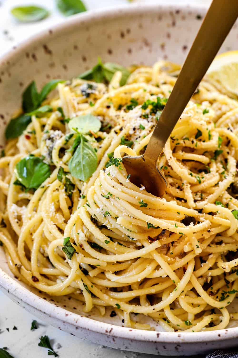 serving lemon pasta recipe (pasta al limone) by twirling it on a fork in a bowl