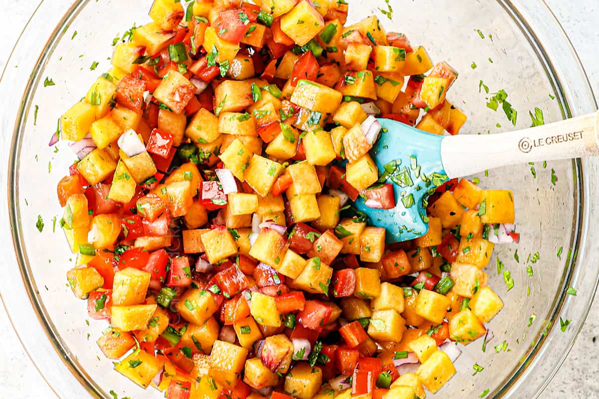 showing how to make Firecracker salmon by adding peach salsa ingredients to a bowl