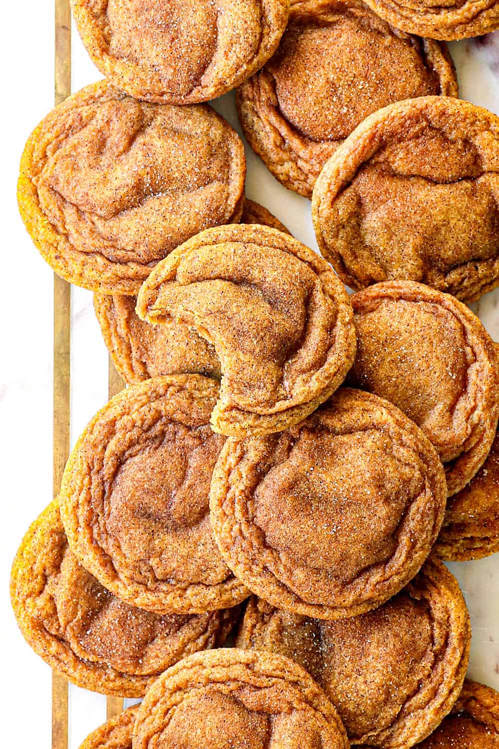 pumpkin snickerdoodle cookies on a marble board with cinnamon sugar