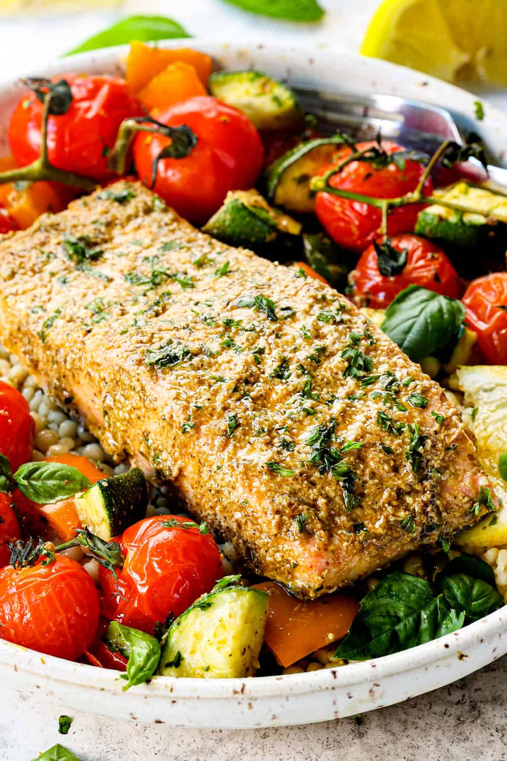 showing how to serve pesto salmon recipe by adding to a bowl of rice with vegetables