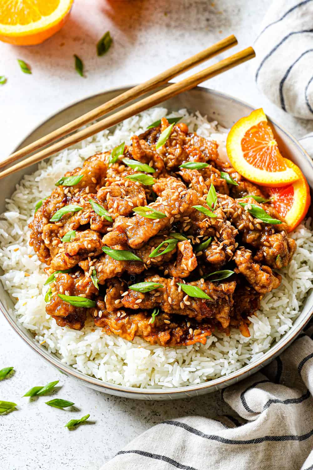 crispy orange beef over rice served with chopsticks