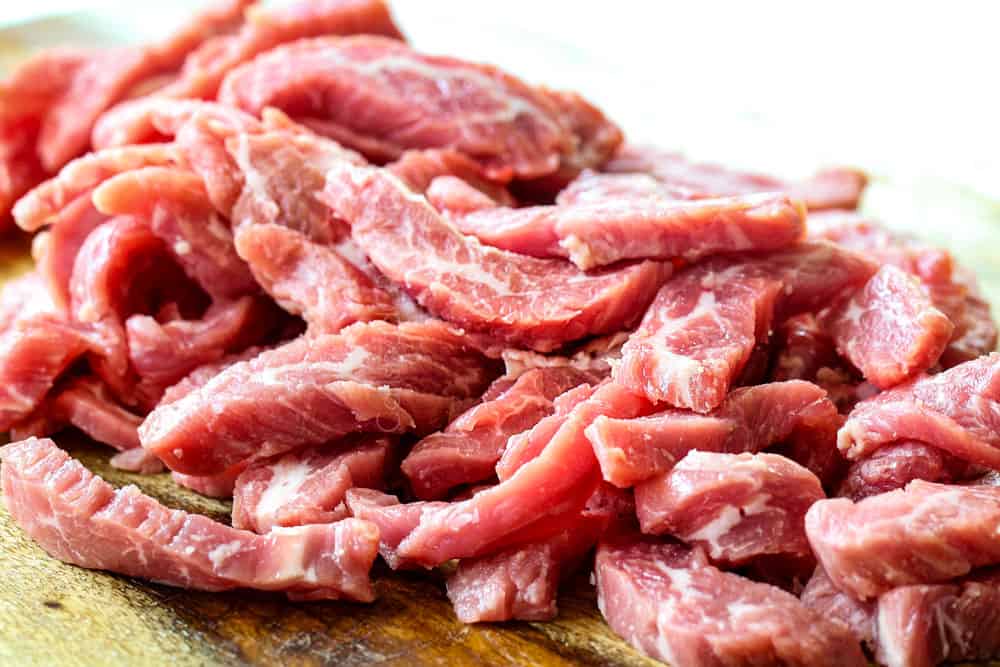 showing how to make orange beef by slicing flank steak into thin strips against the grain