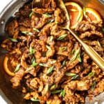 top view of making orange beef by garnishing with green onions and sesame seeds
