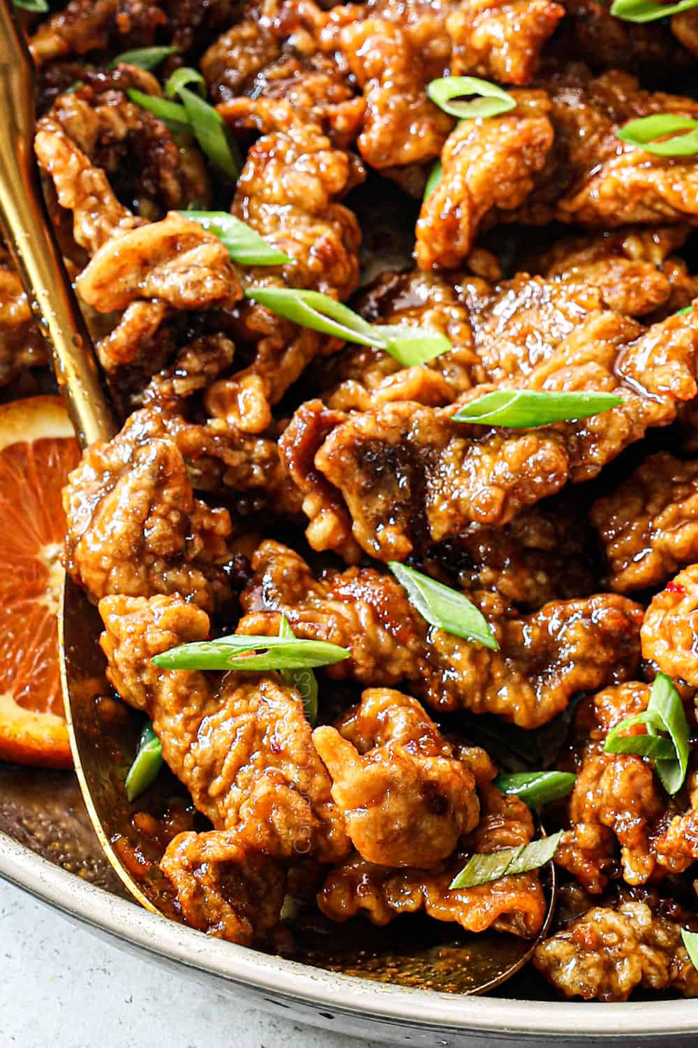 up close of a spoonful of orange beef showing how crispy it is