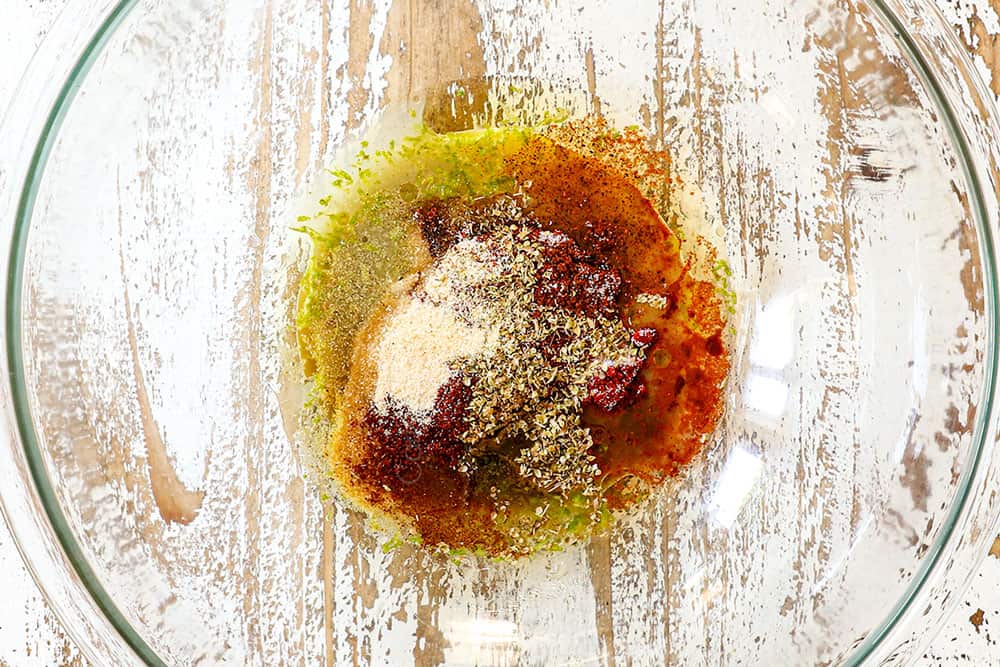 showing how to make sheet pan chicken fajitas by whisking marinade ingredients together in a bowl