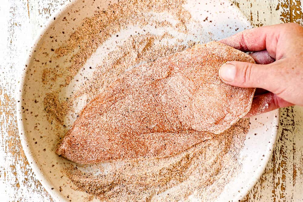 showing how to make smothered chicken by breading the chicken in flour and spices
