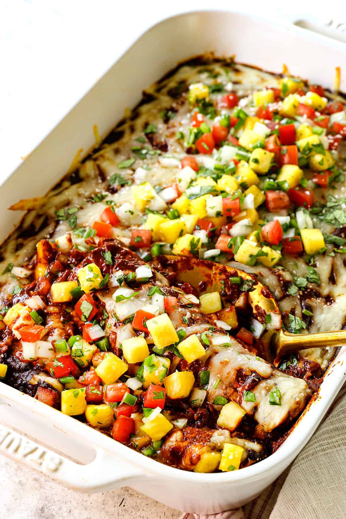 serving chicken mole enchiladas garnished by pineapple