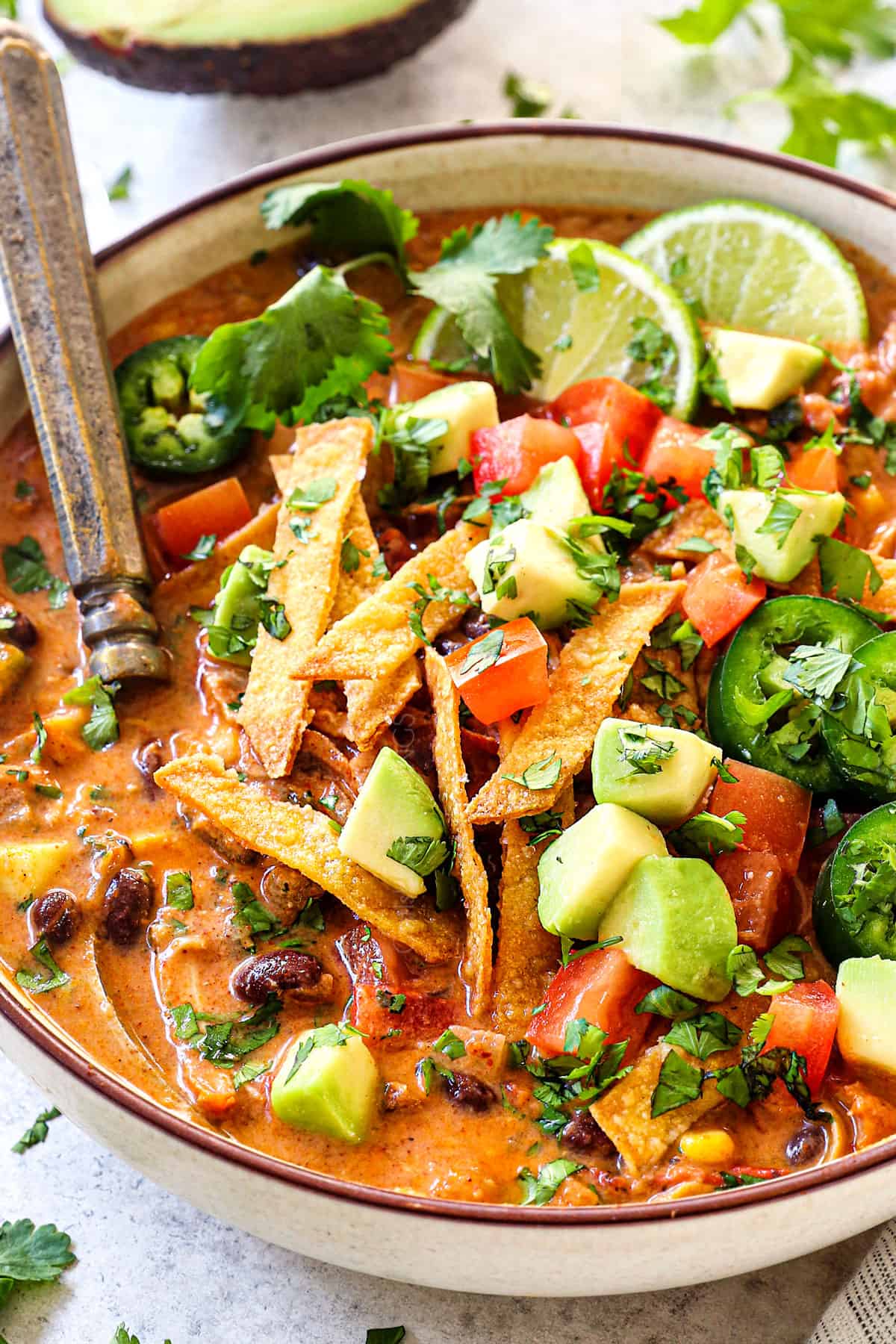 up close of creamy chicken tortilla soup in a bowl showing how creamy this recipe is