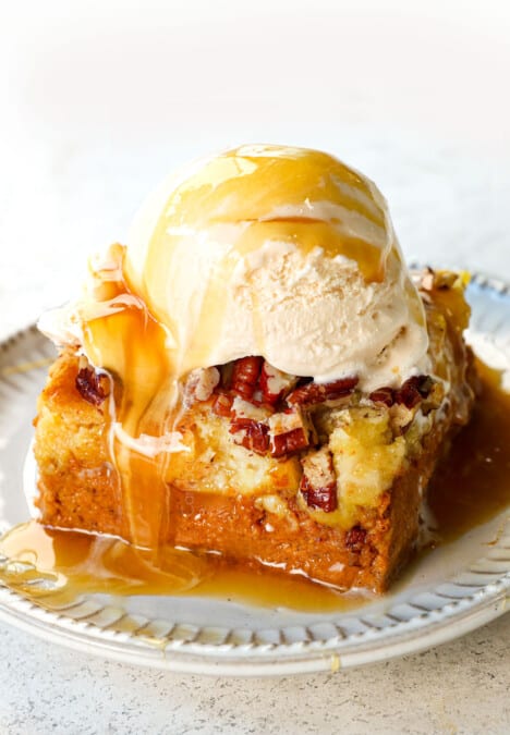 showing how to serve pumpkin dump cake by adding to a plate with whipped cream
