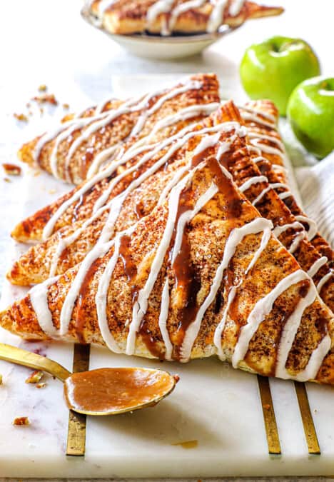 puff pastry apple turnovers lined in a row on a serving tray showing how puffy they are