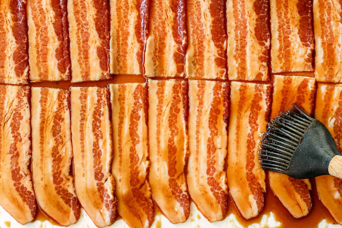 showing how to make Bacon Wrapped Brussels Sprouts by brushing bacon with maple glaze