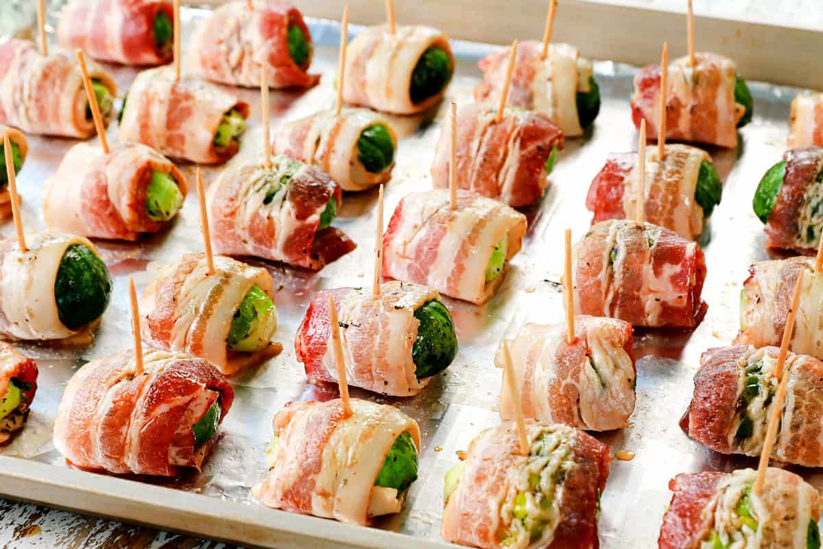 showing how to make Bacon Wrapped Brussels Sprouts by roasting sprouts on a baking sheet until the bacon is crispy