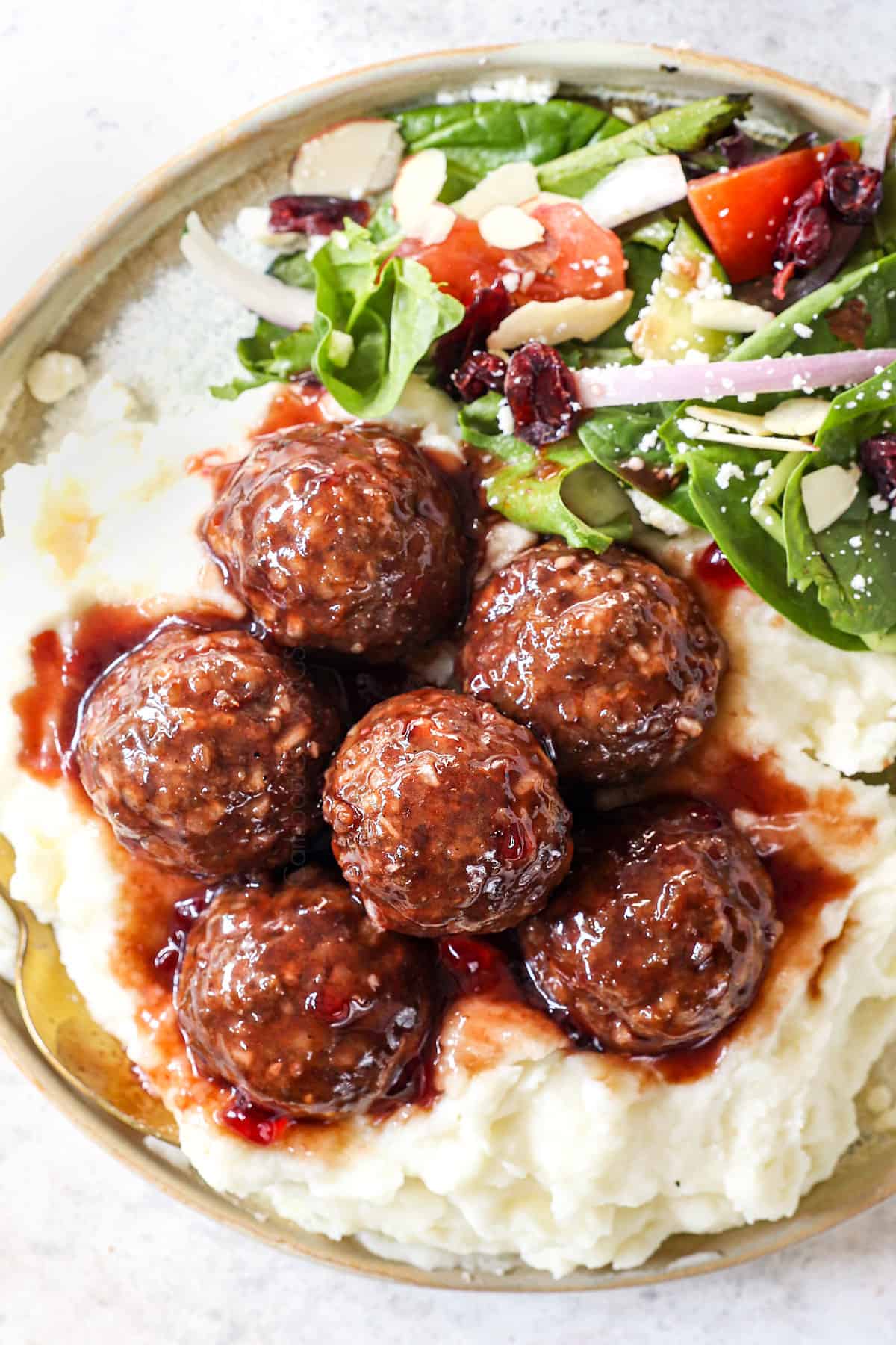 showing how to serve grape jelly meatballs as a main dish with potatoes and salad