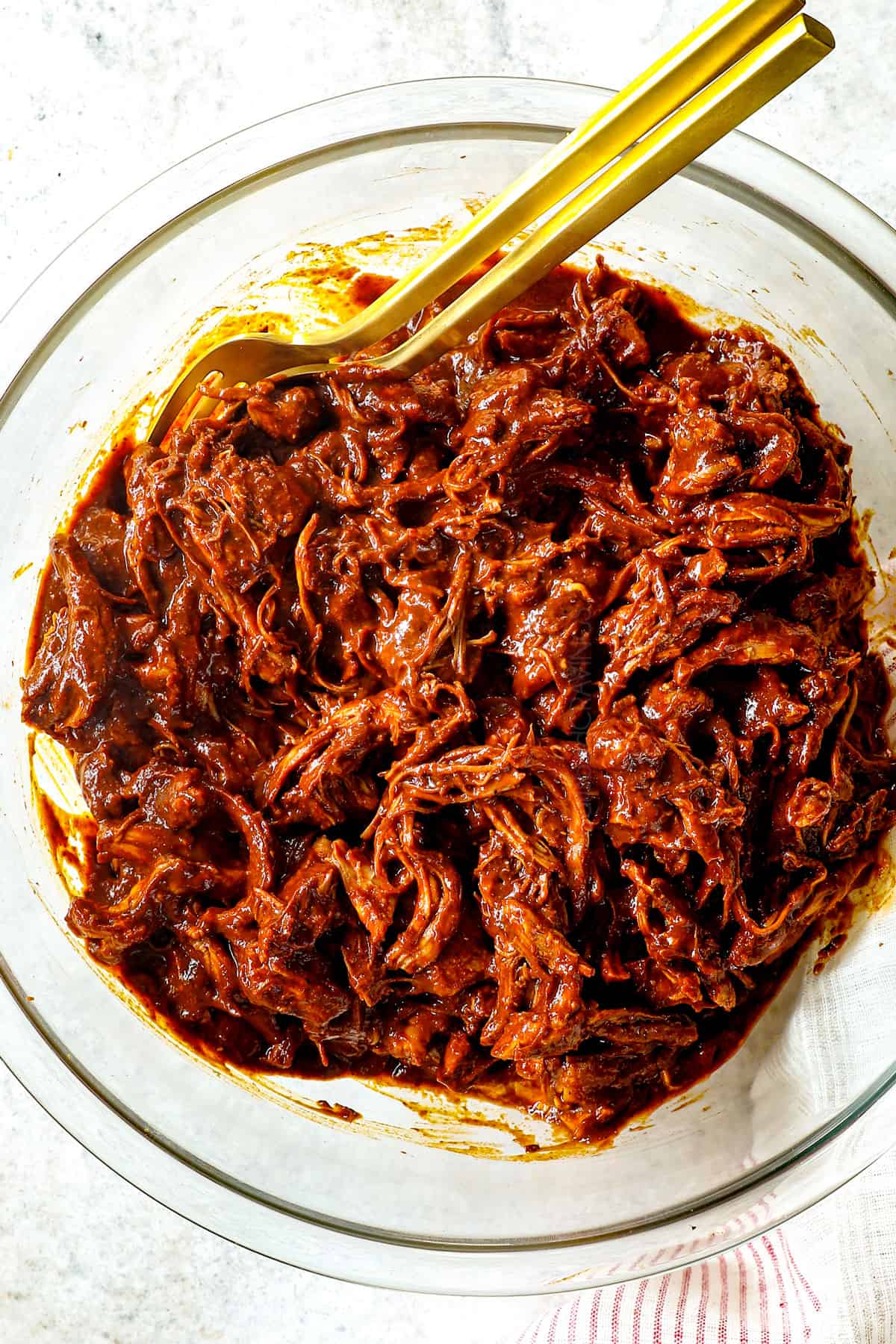 showing how to make chicken mole by combining shredded chicken with mole poblano sauce