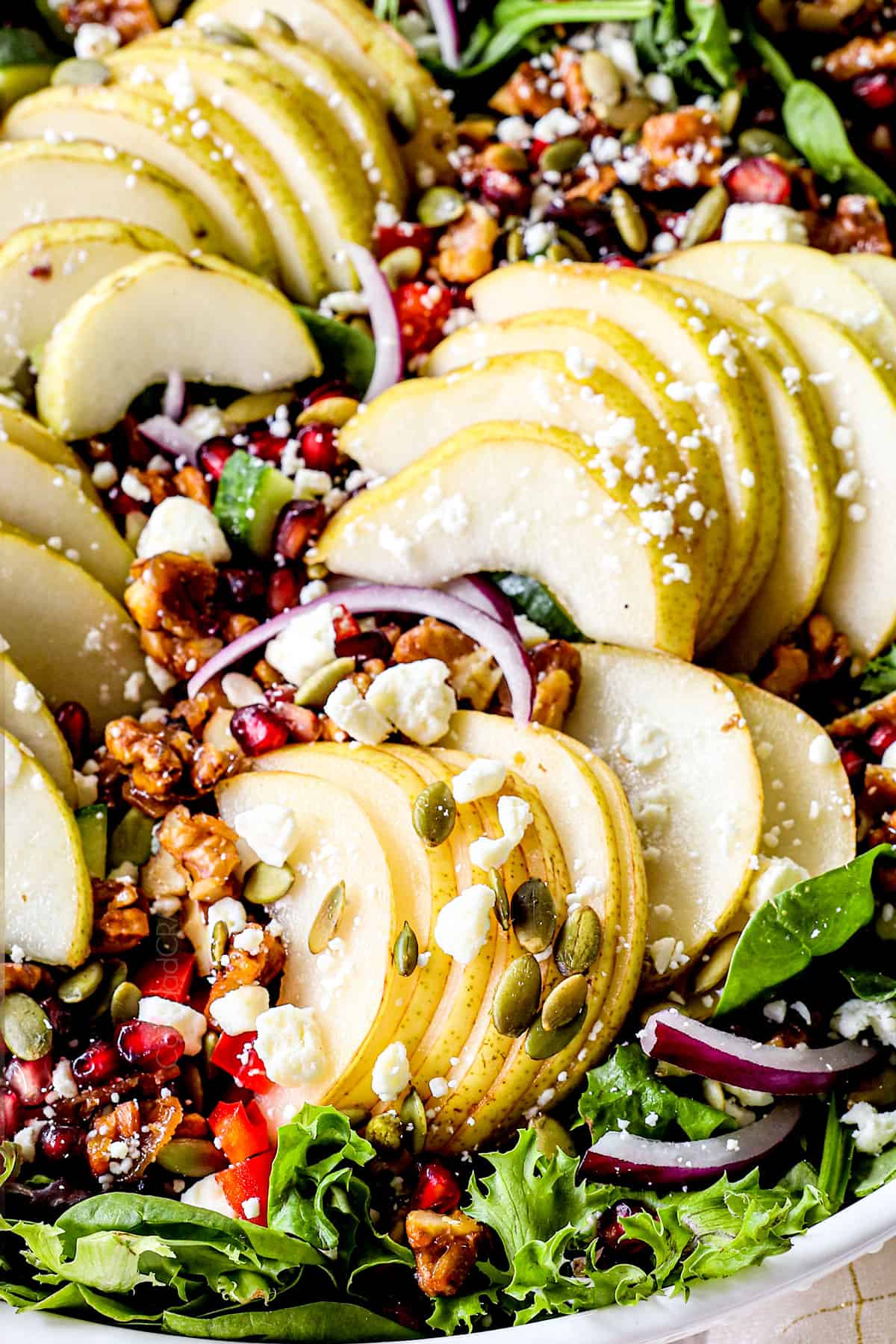pear salad with sliced pears, gorgonzola and walnuts in a white bowl